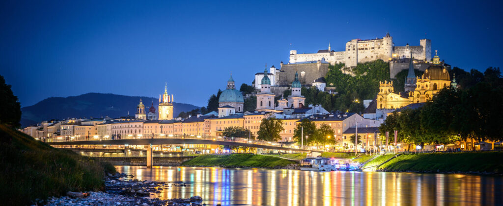Salzach with the historical old city center and the fortress Hohensalzburg during night